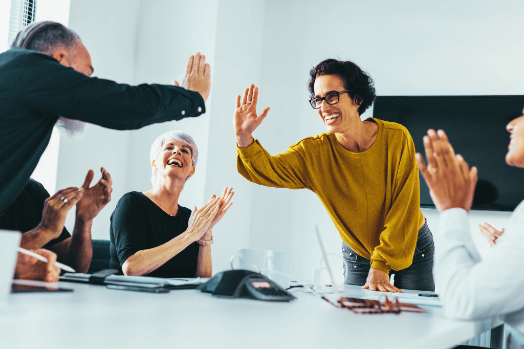 Team high-fiving and celebrating in office