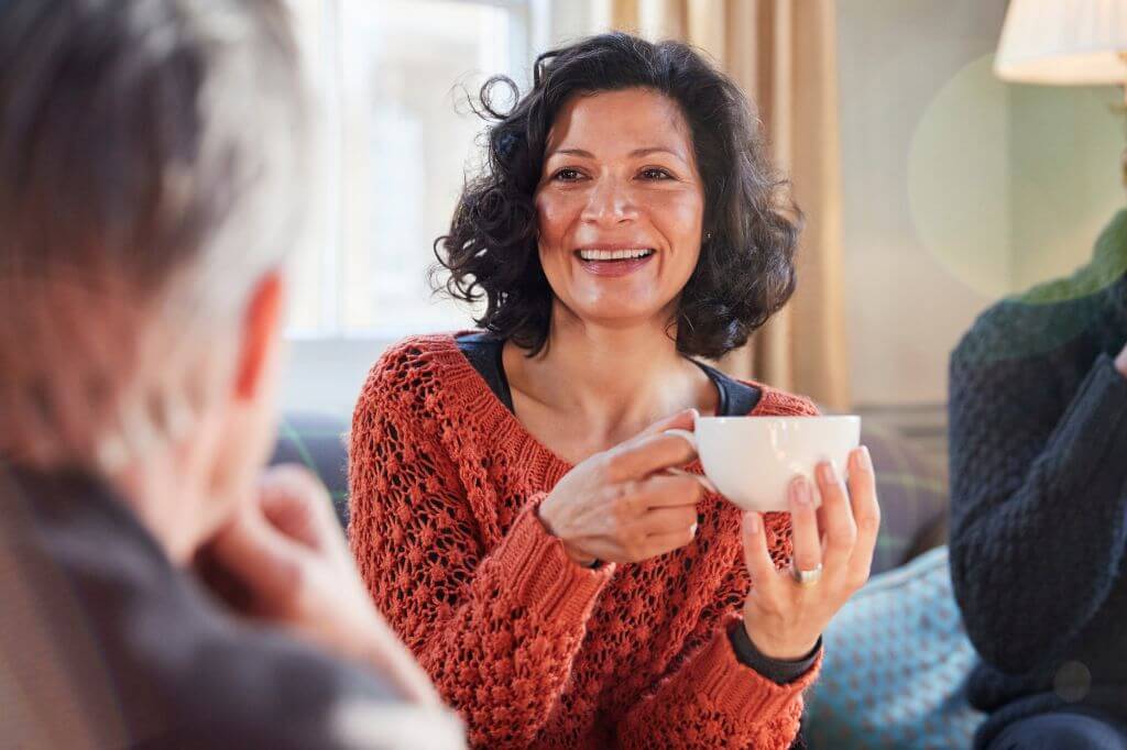 Woman sat chatting drinking a cup of tea